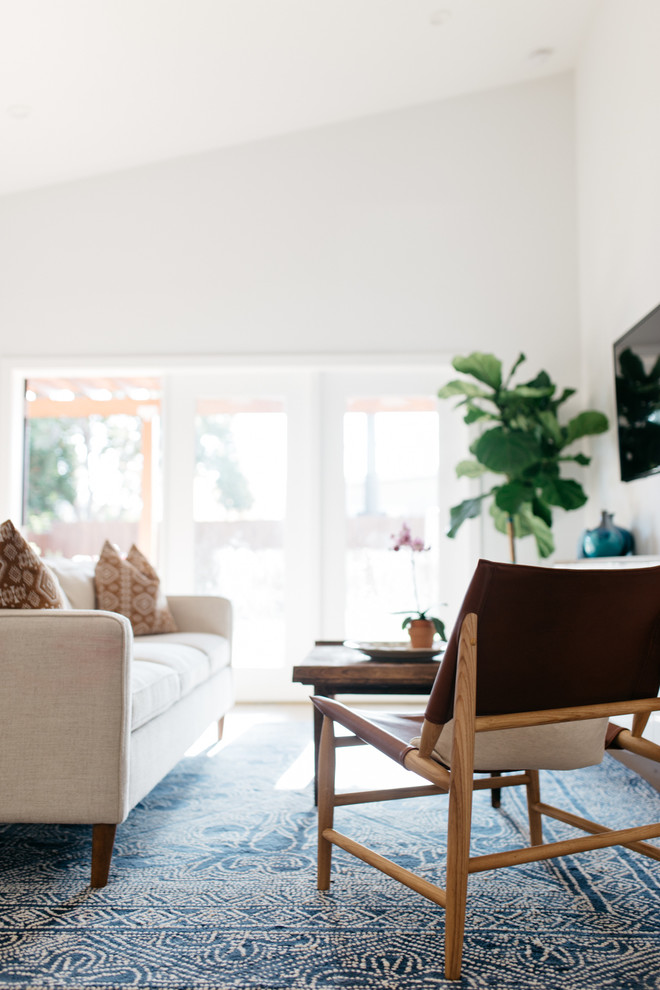 Esempio di un soggiorno classico di medie dimensioni con pareti bianche, parquet chiaro e TV a parete