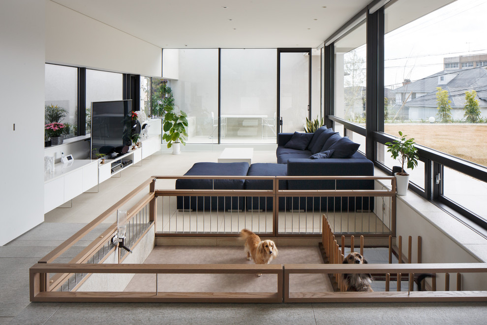 Пример оригинального дизайна: открытая гостиная комната в стиле модернизм с белыми стенами, отдельно стоящим телевизором, бежевым полом и ковровым покрытием без камина