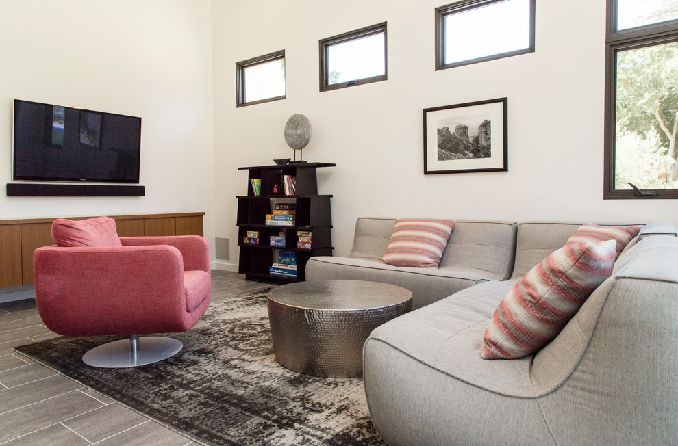 Immagine di un soggiorno design di medie dimensioni e chiuso con pareti bianche, parquet chiaro, nessun camino e TV a parete