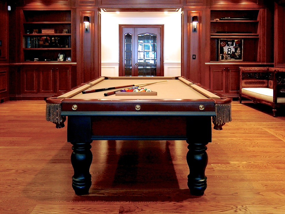 Modelo de sala de juegos en casa clásica grande sin chimenea con paredes marrones, suelo de madera en tonos medios y suelo marrón
