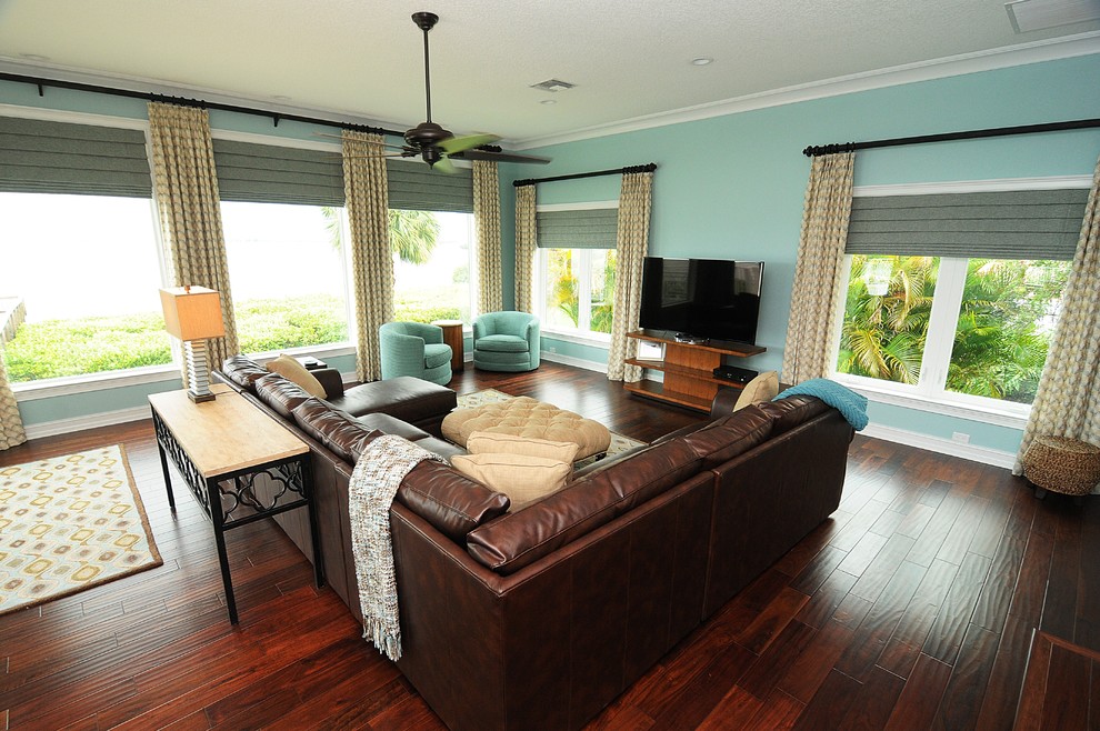 Großes, Offenes Klassisches Wohnzimmer ohne Kamin mit blauer Wandfarbe, dunklem Holzboden, freistehendem TV und braunem Boden in Tampa