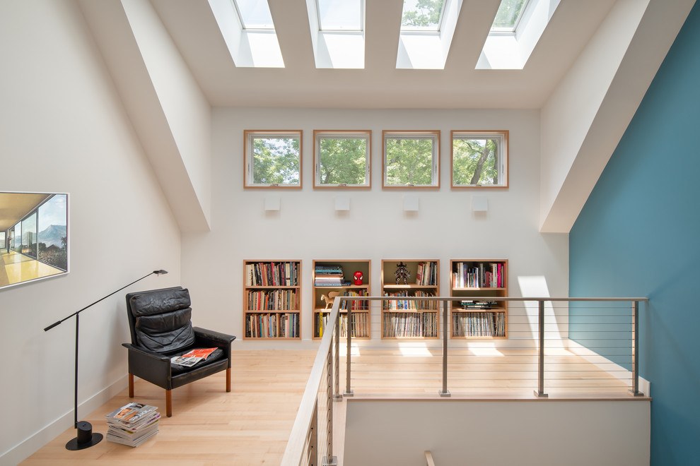 Источник вдохновения для домашнего уюта: гостиная комната в современном стиле с с книжными шкафами и полками, синими стенами, светлым паркетным полом и бежевым полом