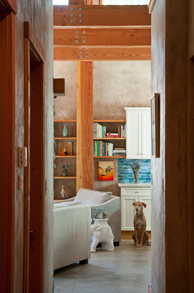 Mittelgroßes, Offenes Uriges Wohnzimmer mit beiger Wandfarbe, Betonboden, Kamin und Kaminumrandung aus Stein in Vancouver