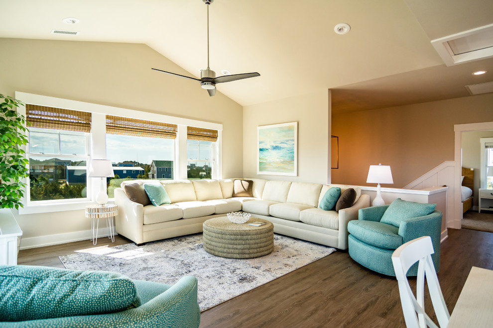 Foto de sala de estar abierta marinera de tamaño medio sin chimenea con paredes beige, suelo marrón y suelo de madera en tonos medios