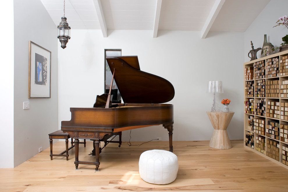 Modelo de sala de estar con rincón musical ecléctica con paredes blancas y suelo de madera clara