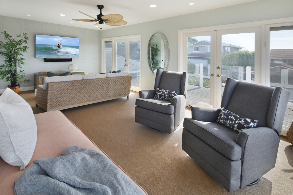 Medium sized beach style enclosed games room in Orange County with a reading nook, blue walls, carpet, a standard fireplace, a wall mounted tv, brown floors and wallpapered walls.