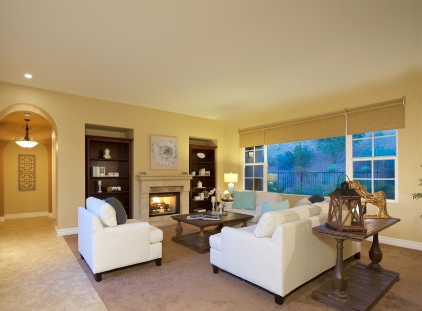 Example of a large beach style open concept carpeted family room design in San Diego with a bar, white walls, a standard fireplace and no tv