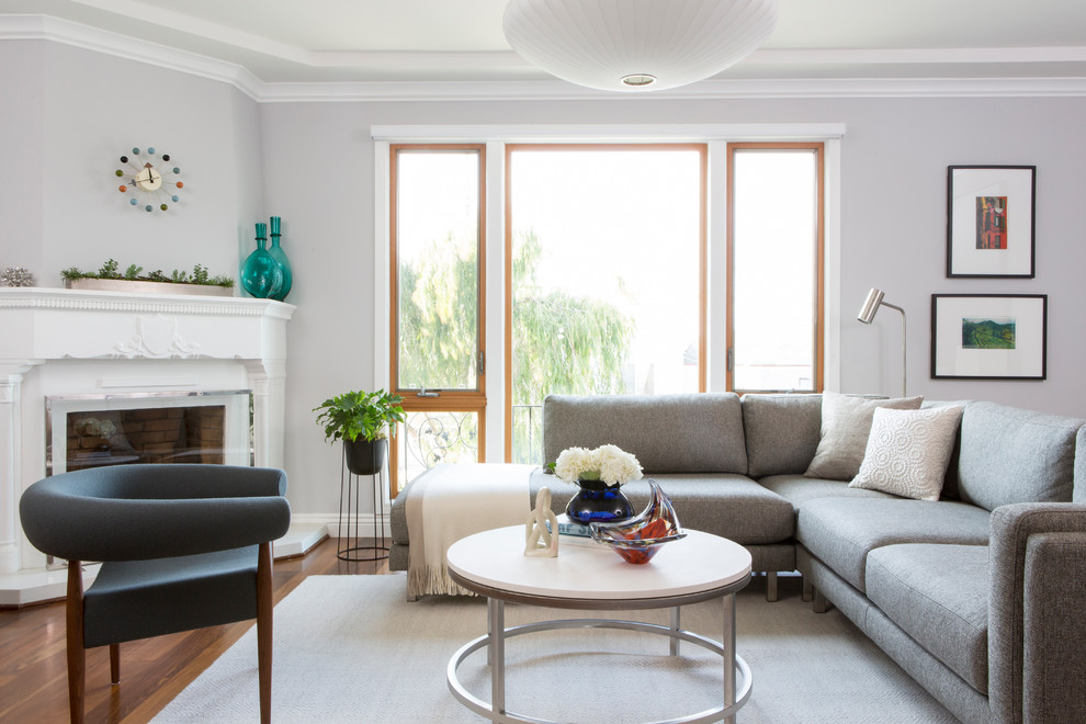 Mittelgroßes, Fernseherloses, Abgetrenntes Klassisches Wohnzimmer mit grauer Wandfarbe, braunem Holzboden, Kamin, braunem Boden und verputzter Kaminumrandung in San Francisco