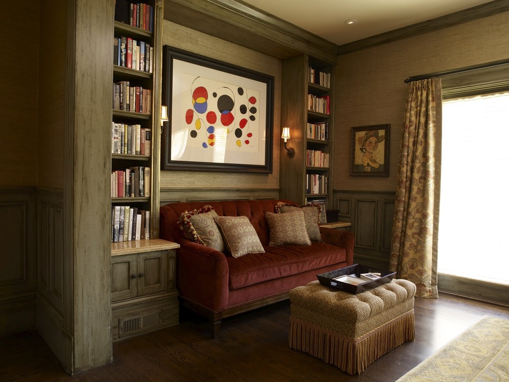 Cette image montre une salle de séjour traditionnelle avec une bibliothèque ou un coin lecture, un mur beige et parquet foncé.