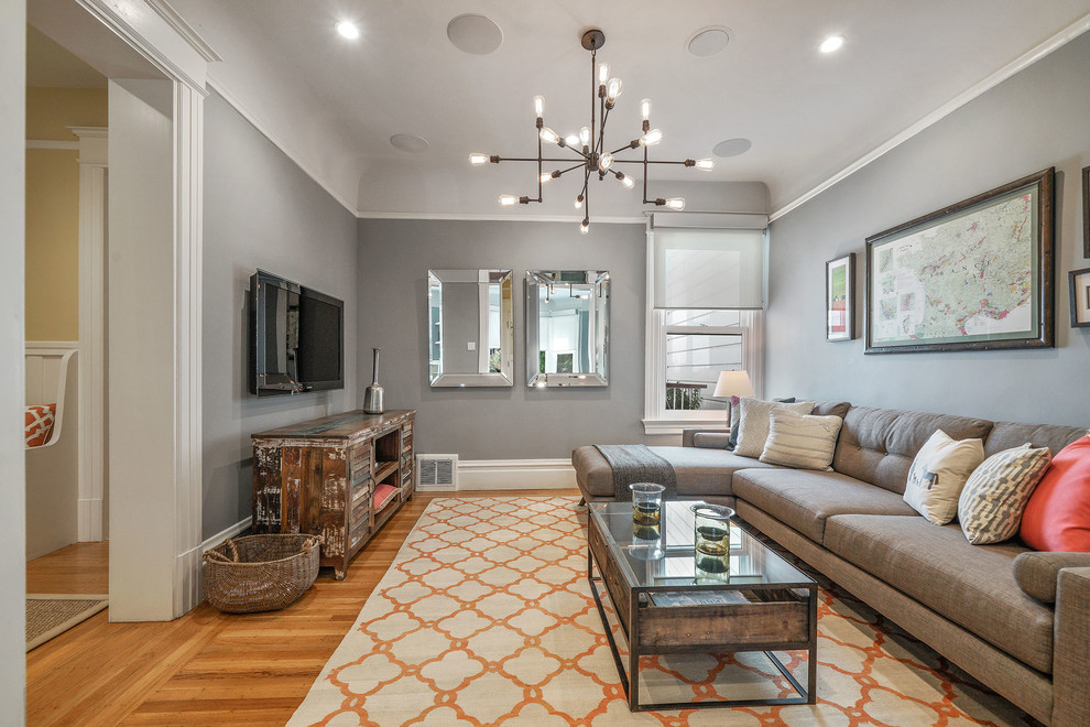 Abgetrenntes Klassisches Wohnzimmer mit grauer Wandfarbe, braunem Holzboden, TV-Wand und braunem Boden in San Francisco