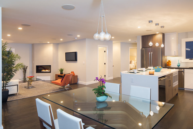 This is an example of a medium sized modern open plan games room in San Francisco with grey walls, dark hardwood flooring, a corner fireplace, a tiled fireplace surround and a wall mounted tv.