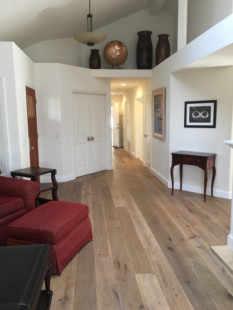 Imagen de sala de estar abierta clásica de tamaño medio con suelo de madera en tonos medios, todas las chimeneas, marco de chimenea de madera y televisor colgado en la pared