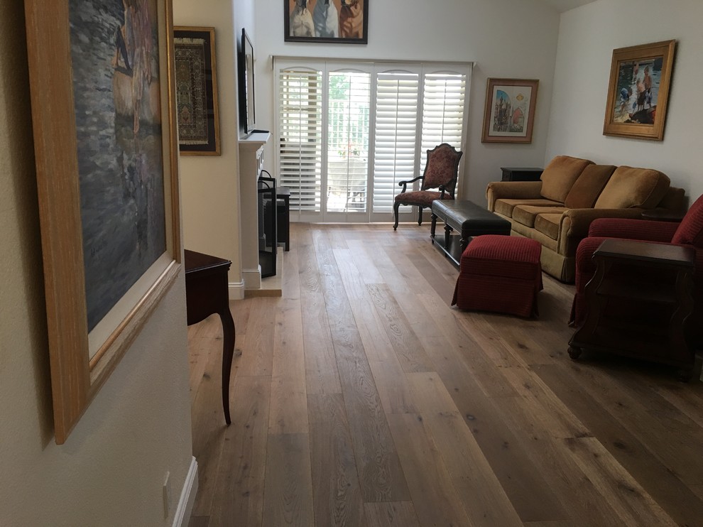 Diseño de sala de estar abierta tradicional de tamaño medio con suelo de madera en tonos medios, todas las chimeneas, marco de chimenea de madera y televisor colgado en la pared