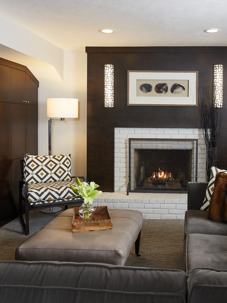 Idée de décoration pour une salle de séjour design de taille moyenne et fermée avec un mur gris, moquette, une cheminée standard et un manteau de cheminée en brique.