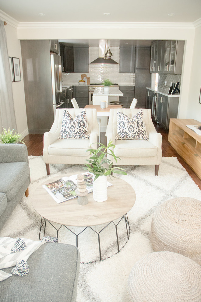 Modelo de sala de estar abierta moderna pequeña con paredes beige, suelo de madera oscura, televisor independiente y suelo marrón