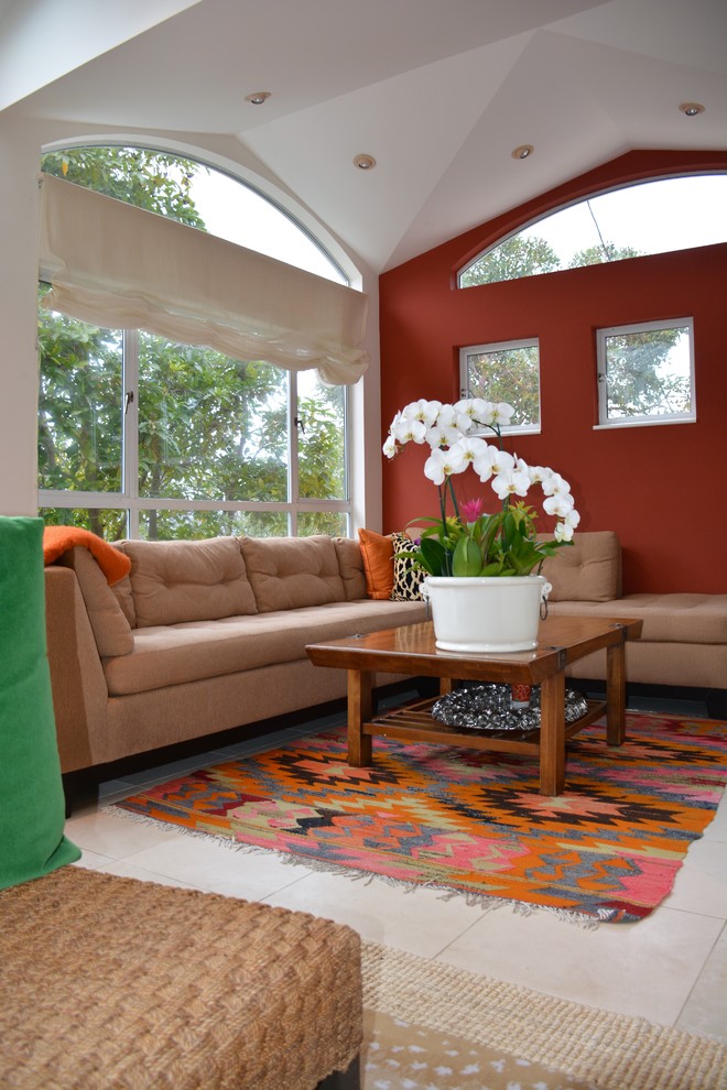 Exemple d'une salle de séjour chic de taille moyenne et ouverte avec une bibliothèque ou un coin lecture, un mur rouge, un sol en calcaire, une cheminée standard, un manteau de cheminée en métal, un téléviseur indépendant et un sol beige.