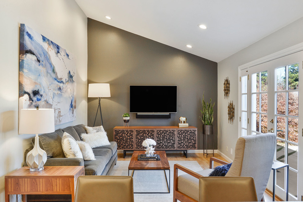 Источник вдохновения для домашнего уюта: гостиная комната среднего размера в стиле неоклассика (современная классика) с серыми стенами, светлым паркетным полом, телевизором на стене и ковром на полу без камина