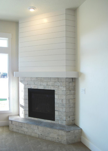 Cette image montre une salle de séjour traditionnelle de taille moyenne et ouverte avec un mur blanc, moquette, une cheminée d'angle, un manteau de cheminée en pierre et aucun téléviseur.