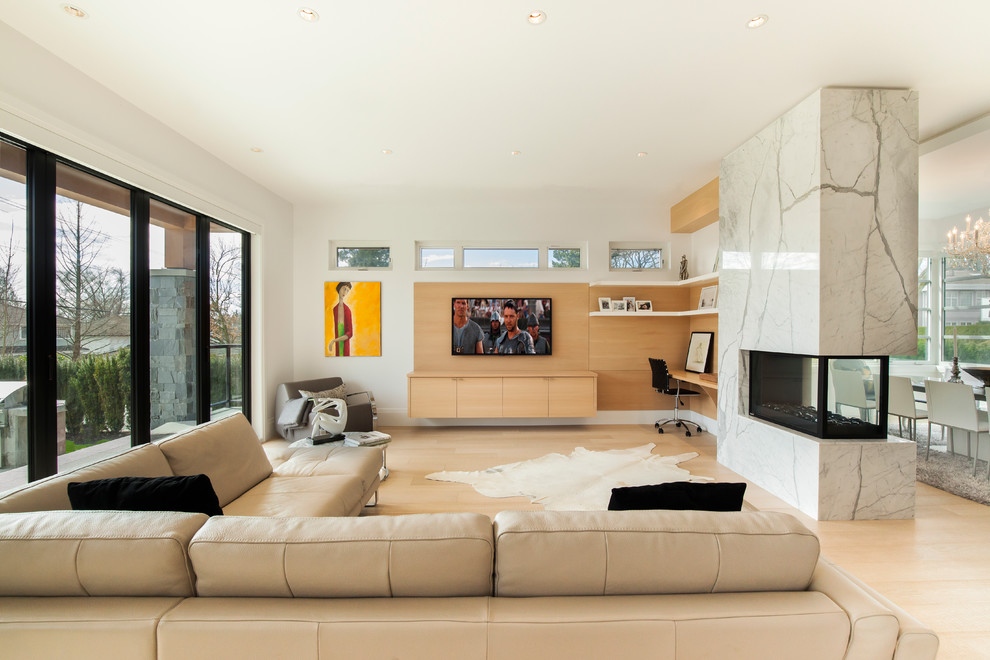 Diseño de sala de estar abierta escandinava con paredes blancas, suelo de madera clara, chimenea de doble cara y televisor colgado en la pared
