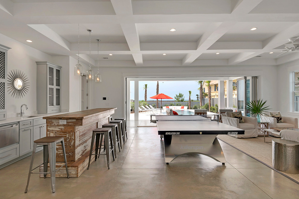 マイアミにある高級な広いビーチスタイルのおしゃれな独立型ファミリールーム (ゲームルーム、白い壁、コンクリートの床、暖炉なし、テレビなし) の写真
