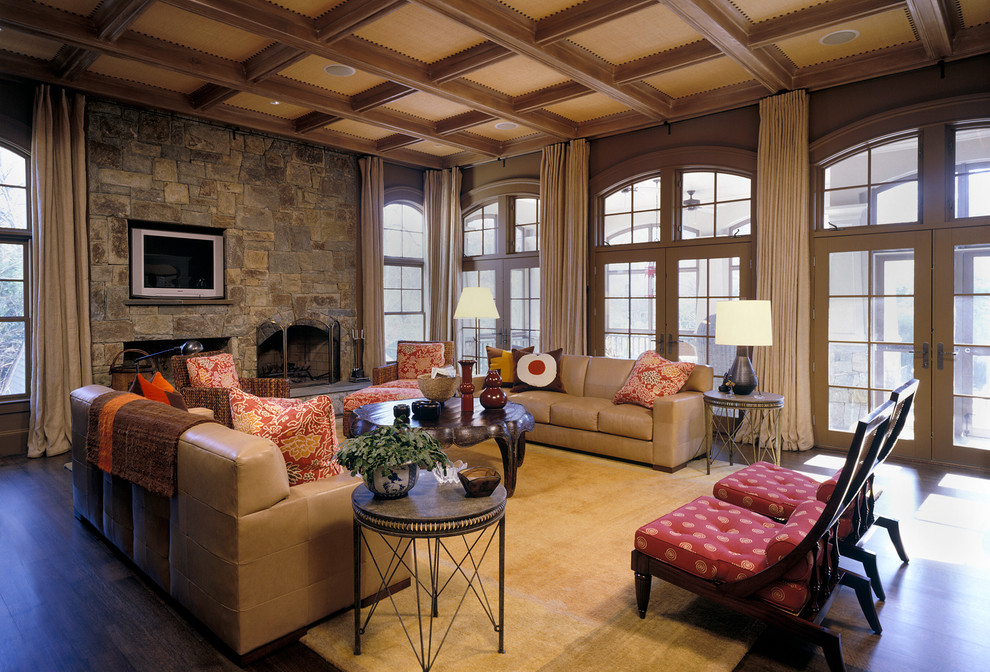 Foto de sala de estar actual con suelo de madera oscura, todas las chimeneas, marco de chimenea de piedra y televisor colgado en la pared
