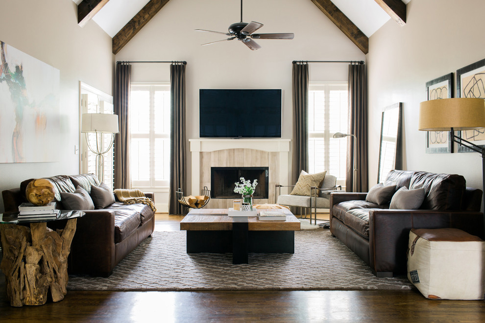 Klassisches Wohnzimmer mit beiger Wandfarbe, dunklem Holzboden, Kamin, gefliester Kaminumrandung und TV-Wand in Atlanta