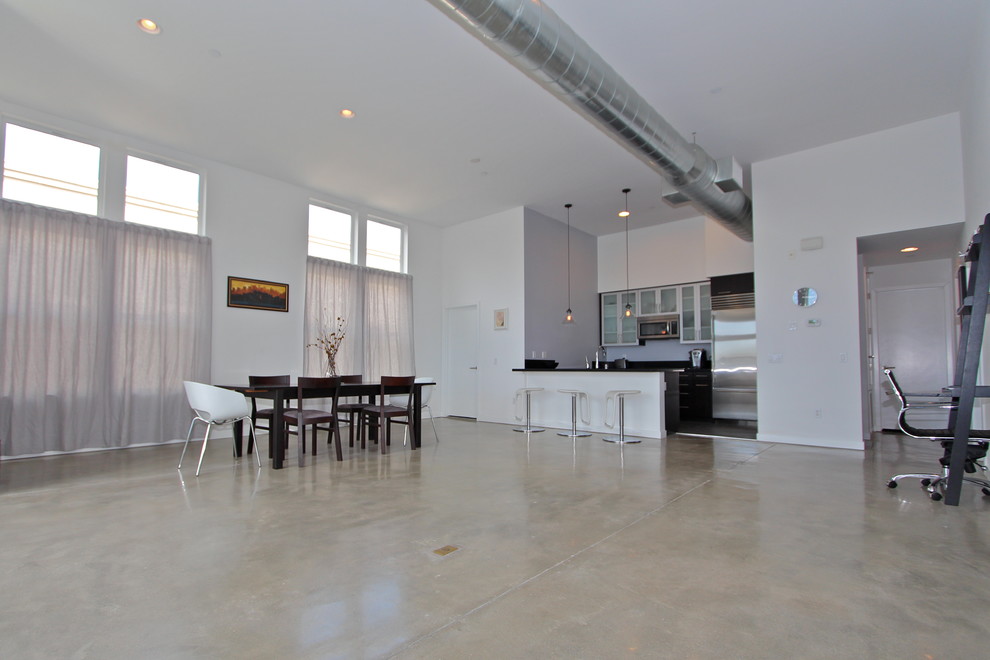 Idee per un ampio soggiorno moderno stile loft con pareti bianche e pavimento in cemento
