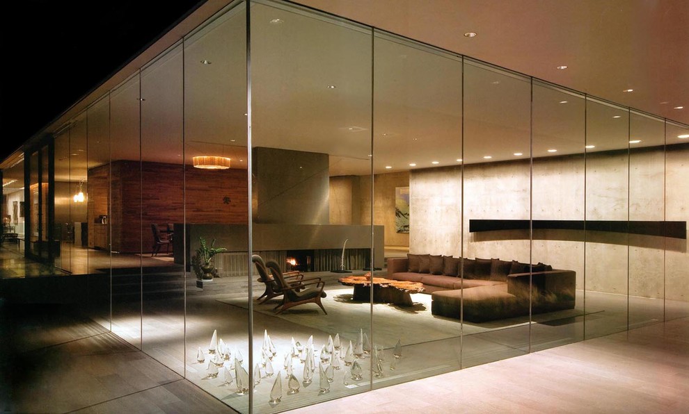 На фото: огромная открытая гостиная комната в стиле модернизм с бежевыми стенами, полом из бамбука, горизонтальным камином, фасадом камина из бетона и бежевым полом без телевизора с