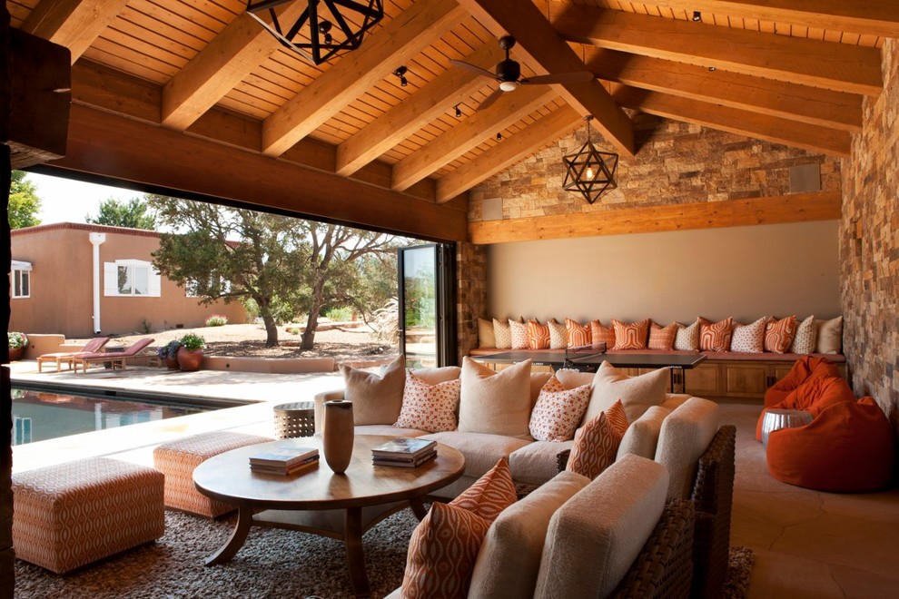 Family room - large rustic open concept carpeted family room idea in Albuquerque with multicolored walls, a standard fireplace, a stone fireplace and a media wall