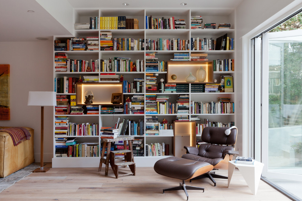 Inspiration för moderna allrum med öppen planlösning, med ett bibliotek, vita väggar, ljust trägolv och beiget golv