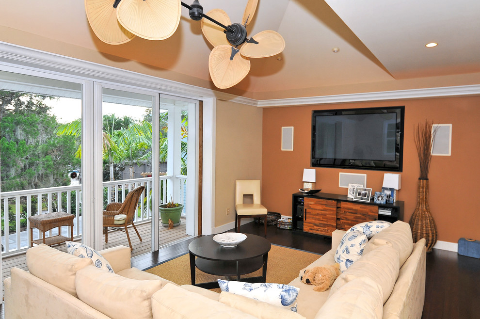 Exempel på ett mellanstort modernt avskilt allrum, med orange väggar, mörkt trägolv, en väggmonterad TV och brunt golv