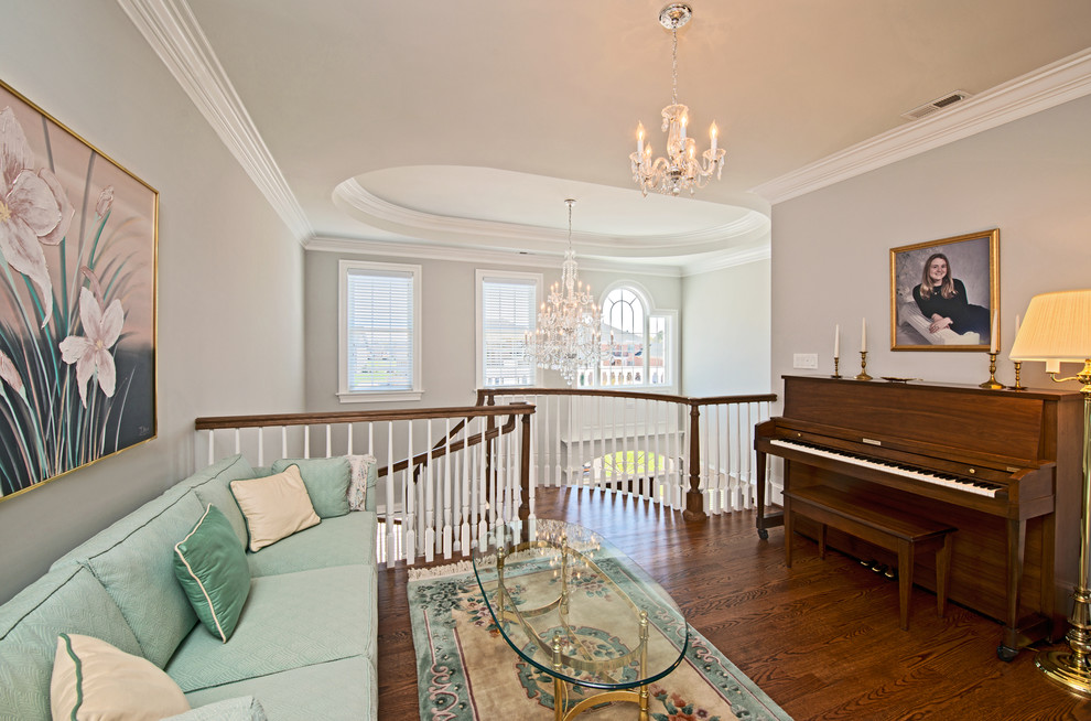 Diseño de sala de estar con rincón musical abierta clásica de tamaño medio sin chimenea con paredes grises, suelo de madera oscura, pared multimedia y suelo marrón