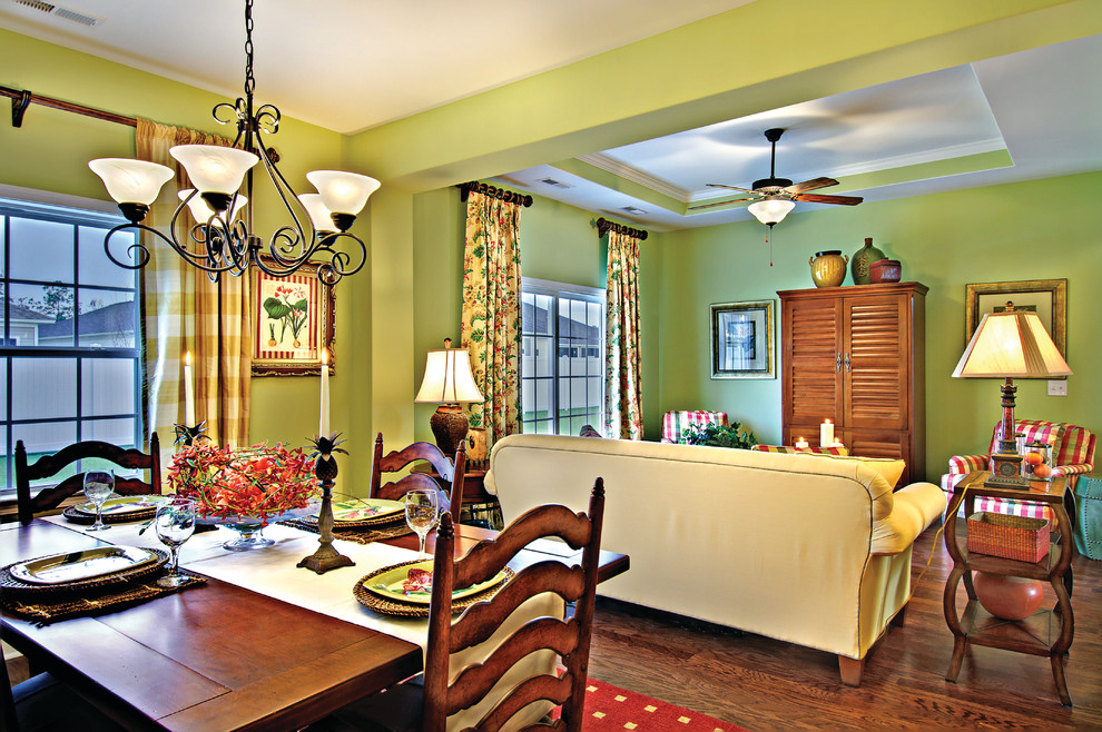 Idée de décoration pour une salle de séjour tradition de taille moyenne et ouverte avec un mur vert, parquet foncé, aucune cheminée et un téléviseur dissimulé.