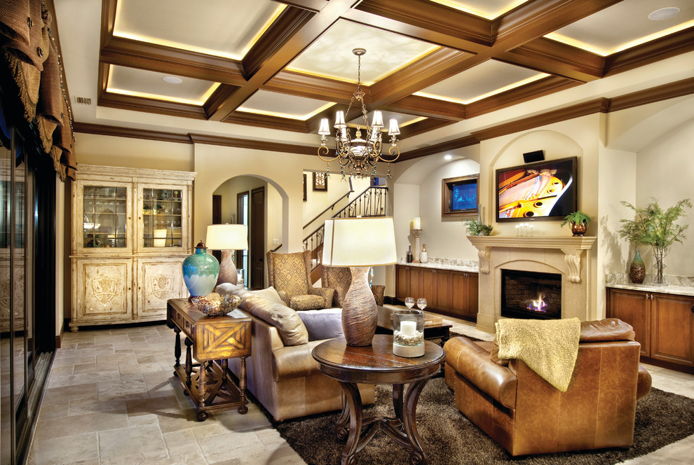 Example of a large tuscan open concept travertine floor family room design in Miami with beige walls, a standard fireplace, a stone fireplace and a wall-mounted tv