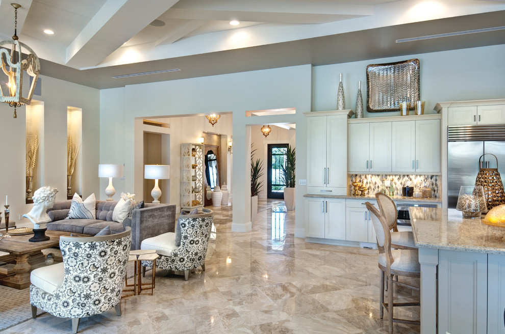 Diseño de sala de estar abierta mediterránea grande sin chimenea con paredes beige y suelo de mármol