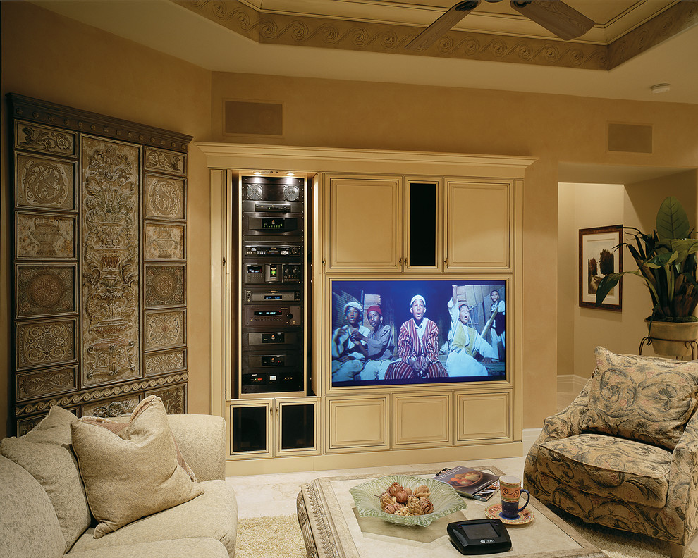Ejemplo de sala de estar abierta mediterránea grande sin chimenea con paredes beige, suelo de travertino y pared multimedia