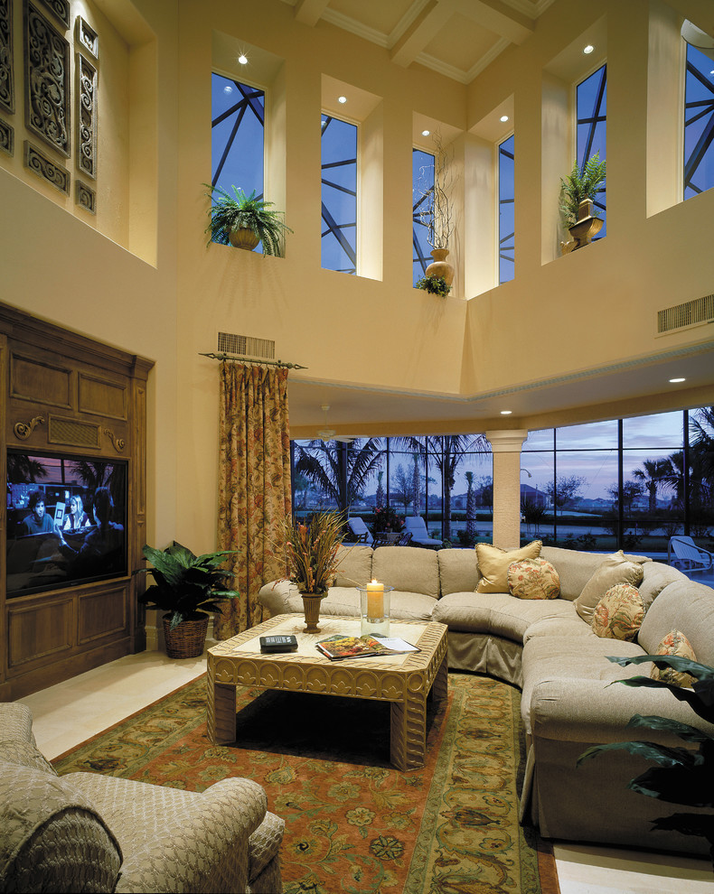 This is an example of a large mediterranean open plan games room in Miami with beige walls, travertine flooring, no fireplace and a built-in media unit.