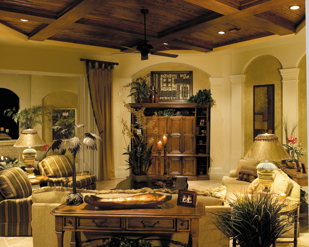 Foto de sala de estar abierta mediterránea grande sin chimenea con paredes beige, suelo de travertino y pared multimedia