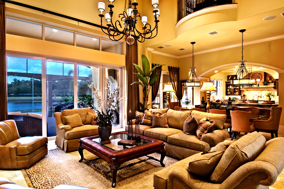 Imagen de sala de estar abierta mediterránea grande sin chimenea con paredes amarillas, suelo de travertino y pared multimedia