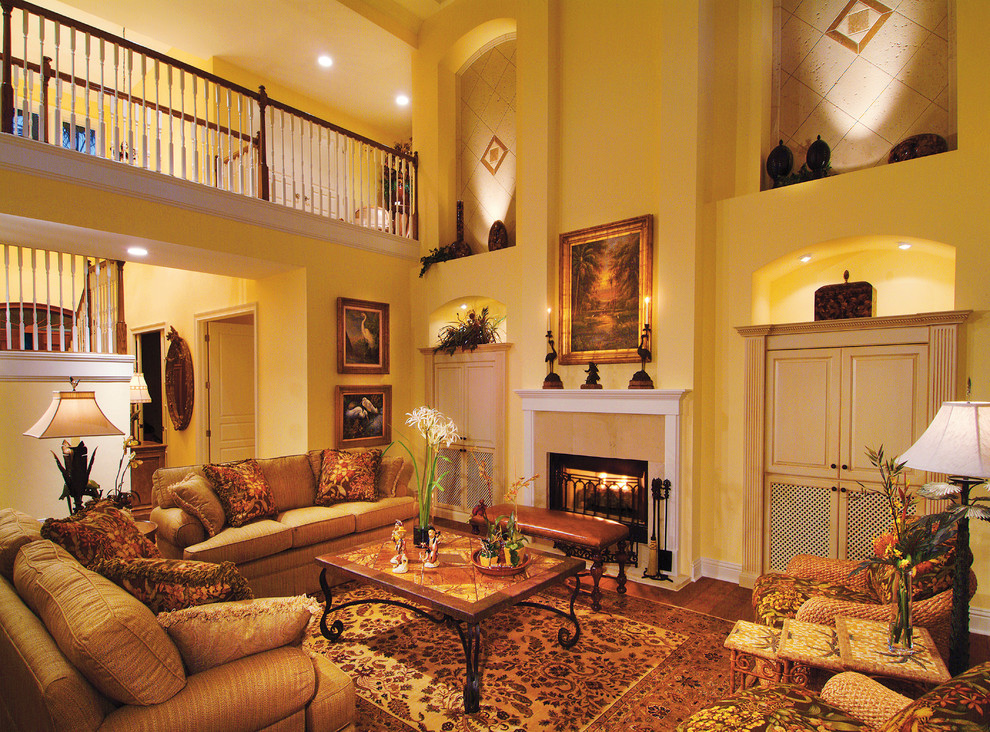 Cette image montre une grande salle de séjour rustique ouverte avec un mur jaune, un sol en bois brun, une cheminée standard, un manteau de cheminée en carrelage et un téléviseur dissimulé.