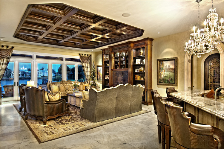 Family room library - large mediterranean enclosed travertine floor family room library idea in Miami with beige walls, no fireplace and a media wall
