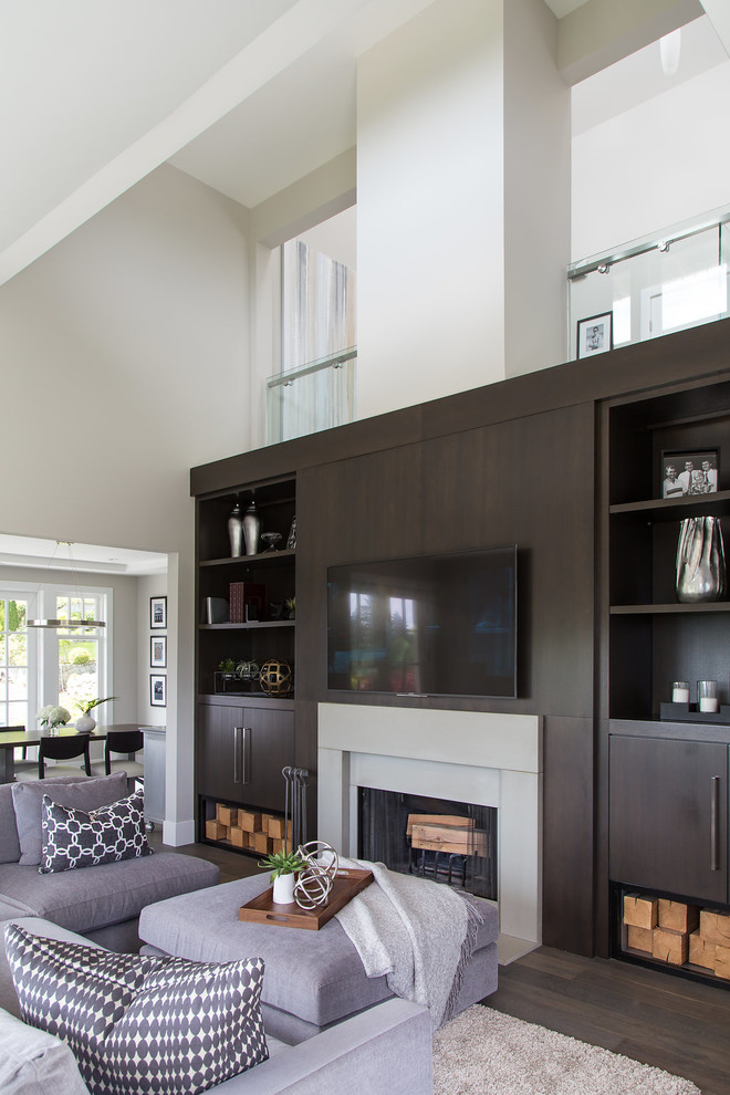 This is an example of a medium sized contemporary enclosed games room in Vancouver with beige walls, dark hardwood flooring, a standard fireplace, a concrete fireplace surround, a wall mounted tv and brown floors.