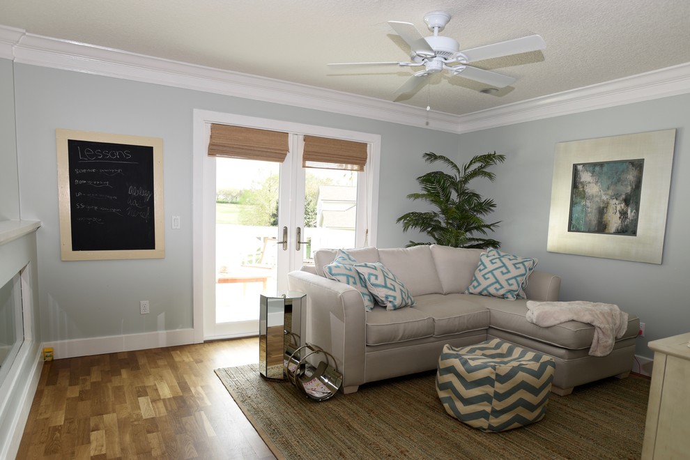 Diseño de sala de estar abierta marinera de tamaño medio sin chimenea y televisor con paredes azules, suelo de madera en tonos medios y suelo beige