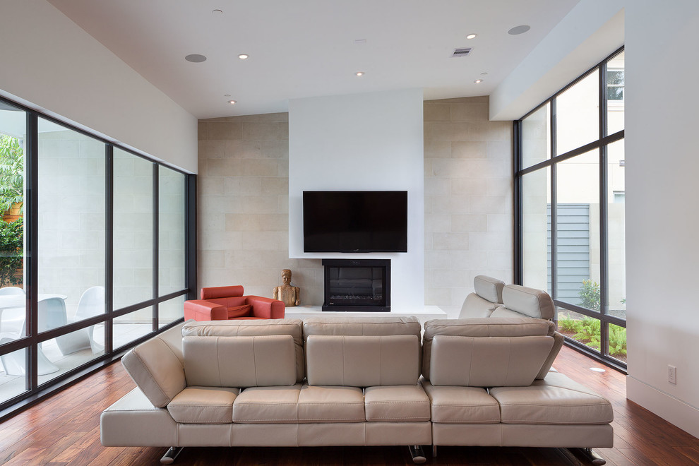 Imagen de sala de estar abierta actual de tamaño medio con paredes blancas, todas las chimeneas y marco de chimenea de yeso