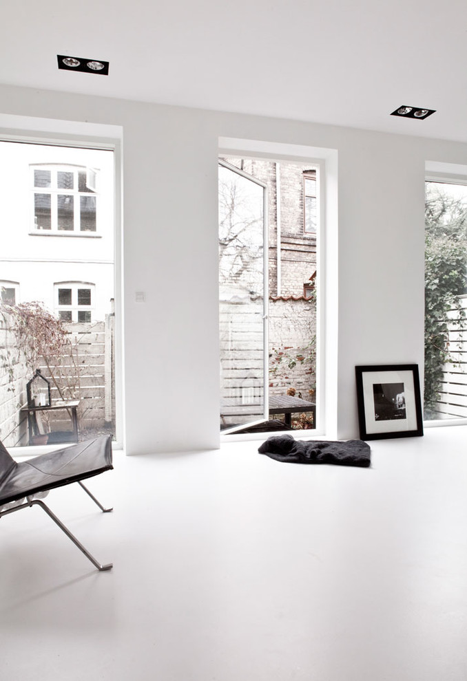 Пример оригинального дизайна: изолированная гостиная комната среднего размера в скандинавском стиле с белыми стенами и телевизором на стене без камина