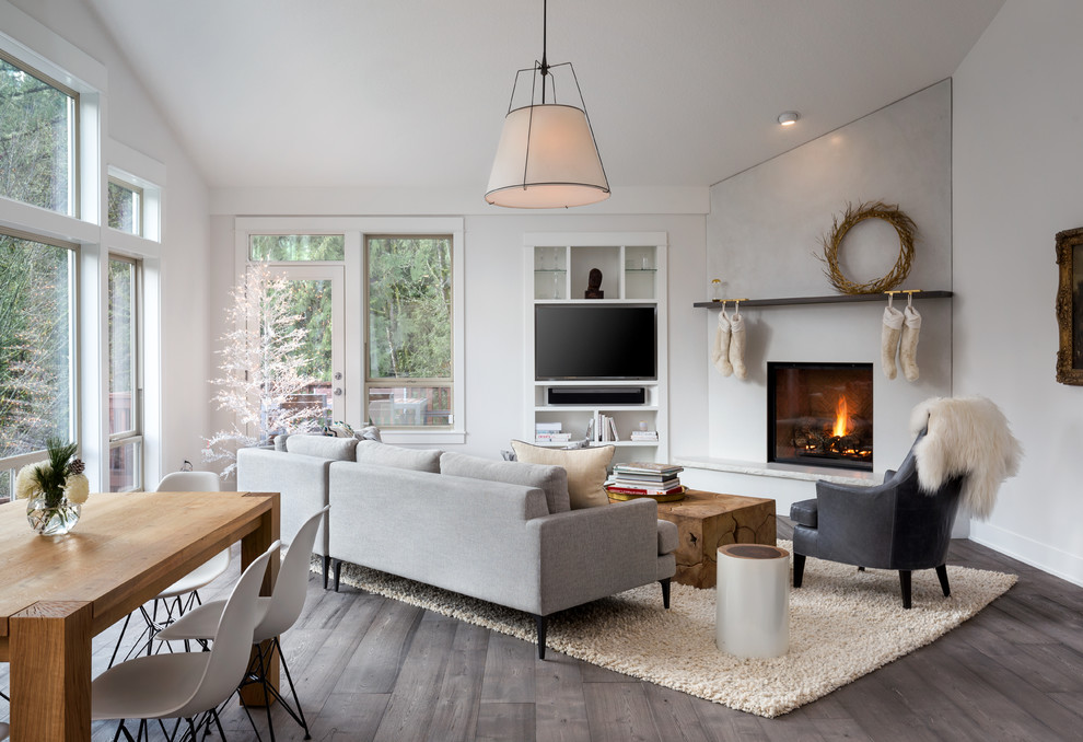 Inspiration for a large scandinavian open concept dark wood floor and gray floor family room remodel in Portland with white walls, a corner fireplace, a concrete fireplace and a media wall