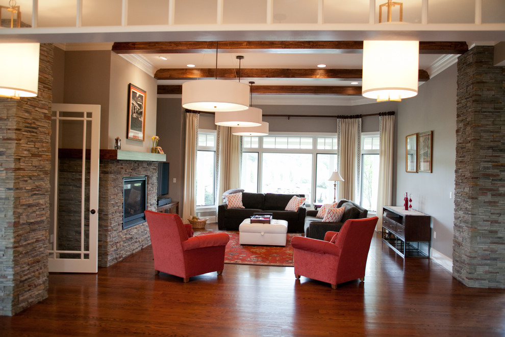 Cette image montre une salle de séjour design de taille moyenne et ouverte avec un mur gris, un sol en bois brun, une cheminée standard, un manteau de cheminée en pierre et un téléviseur indépendant.
