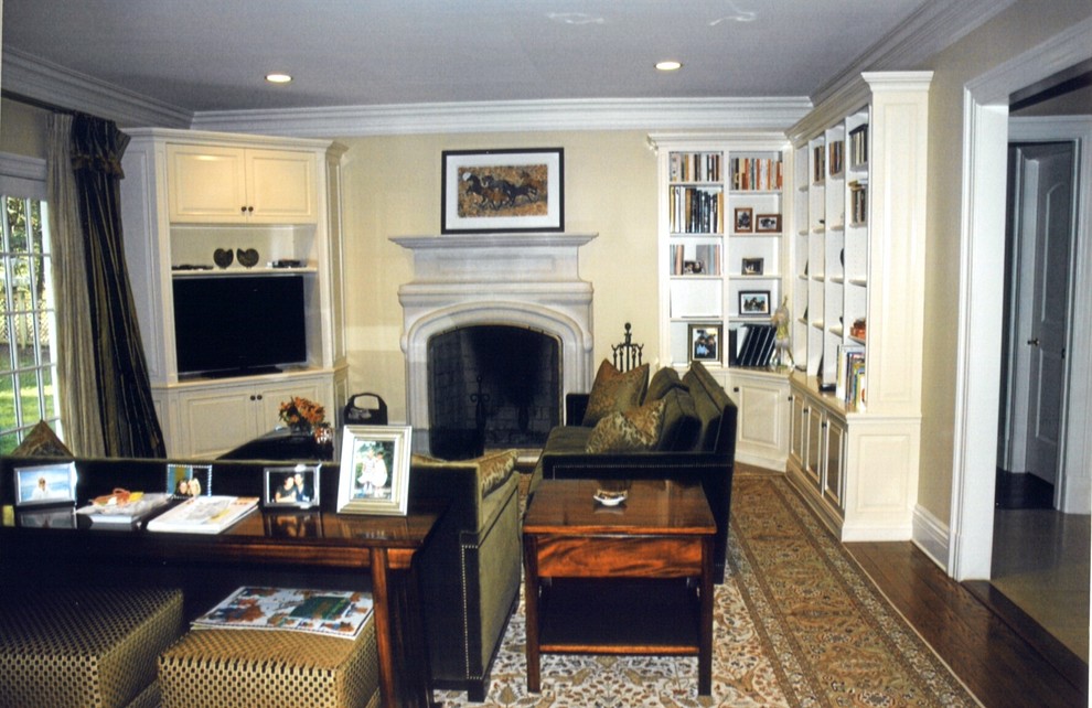 Ejemplo de sala de estar cerrada tradicional grande con paredes amarillas, suelo de madera oscura, todas las chimeneas, marco de chimenea de piedra y televisor en una esquina