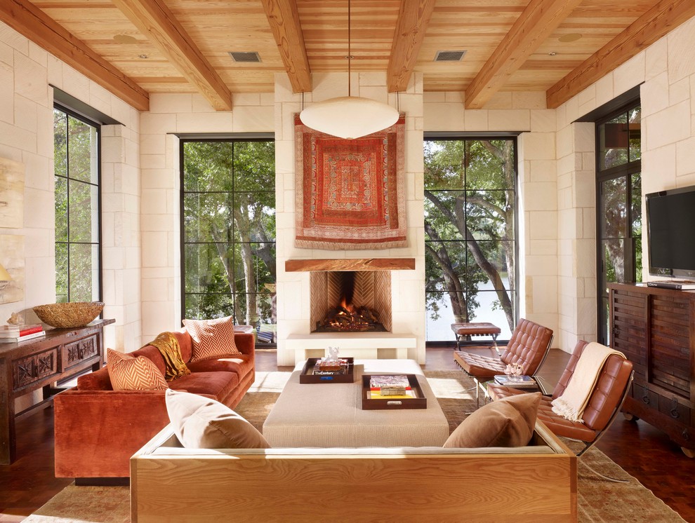 Mediterranes Wohnzimmer mit weißer Wandfarbe, dunklem Holzboden und Kamin in Austin