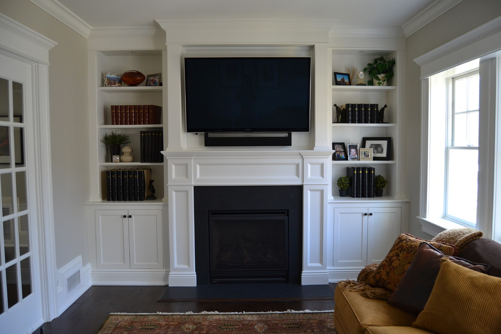 Exemple d'une grande salle de séjour chic ouverte avec un mur blanc, parquet foncé et un téléviseur encastré.
